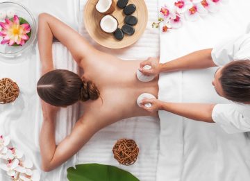 woman-spa-thai-massage-tow-view-beauty-treatments-concept-orchid-lotus-flowers-coconut-stones-herb-pouches-less-scaled.jpg
